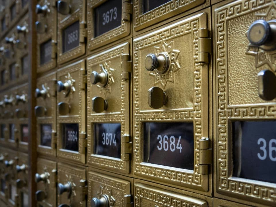 A wall of numbered brass post office boxes with combination dials, every item destined for exactly one box