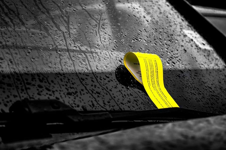 A dated permit sticker on a car windscreen, its validity period printed in small type